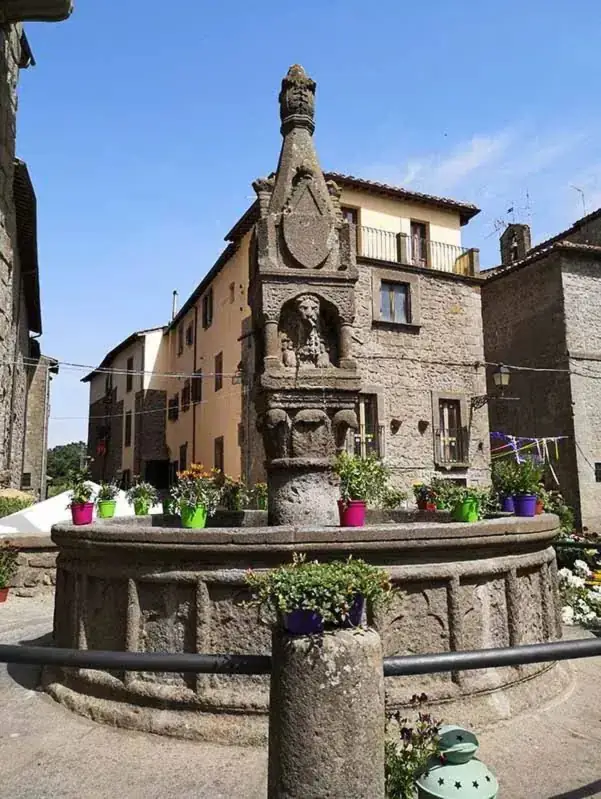 Un vicolo del centro storico di Vitorchiano con le case in peperino e una fontana