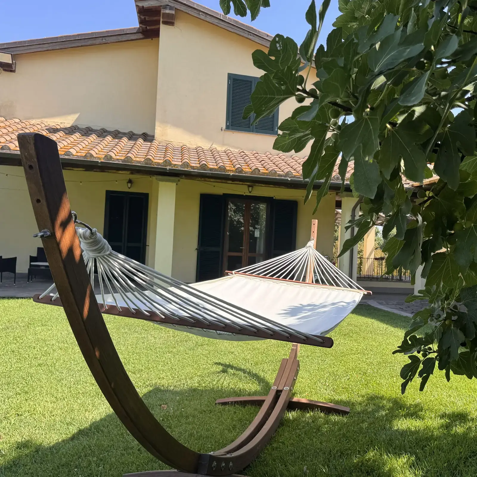 Amaca sospesa fra gli alberi sul prato dell'Oasi del Verde, con la casa sullo sfondo