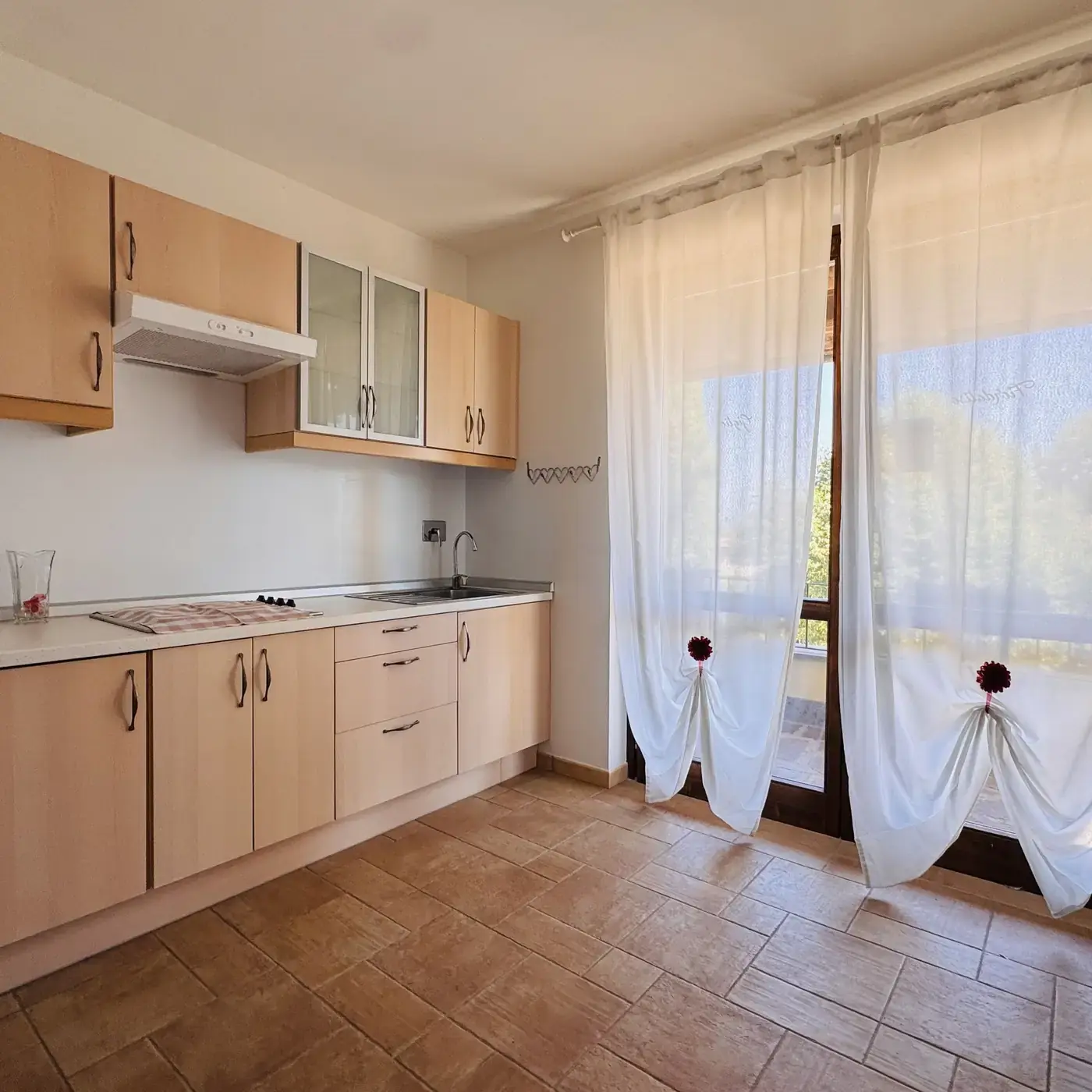 Angolo cucina attrezzato con piano cottura e ampia finestra luminosa