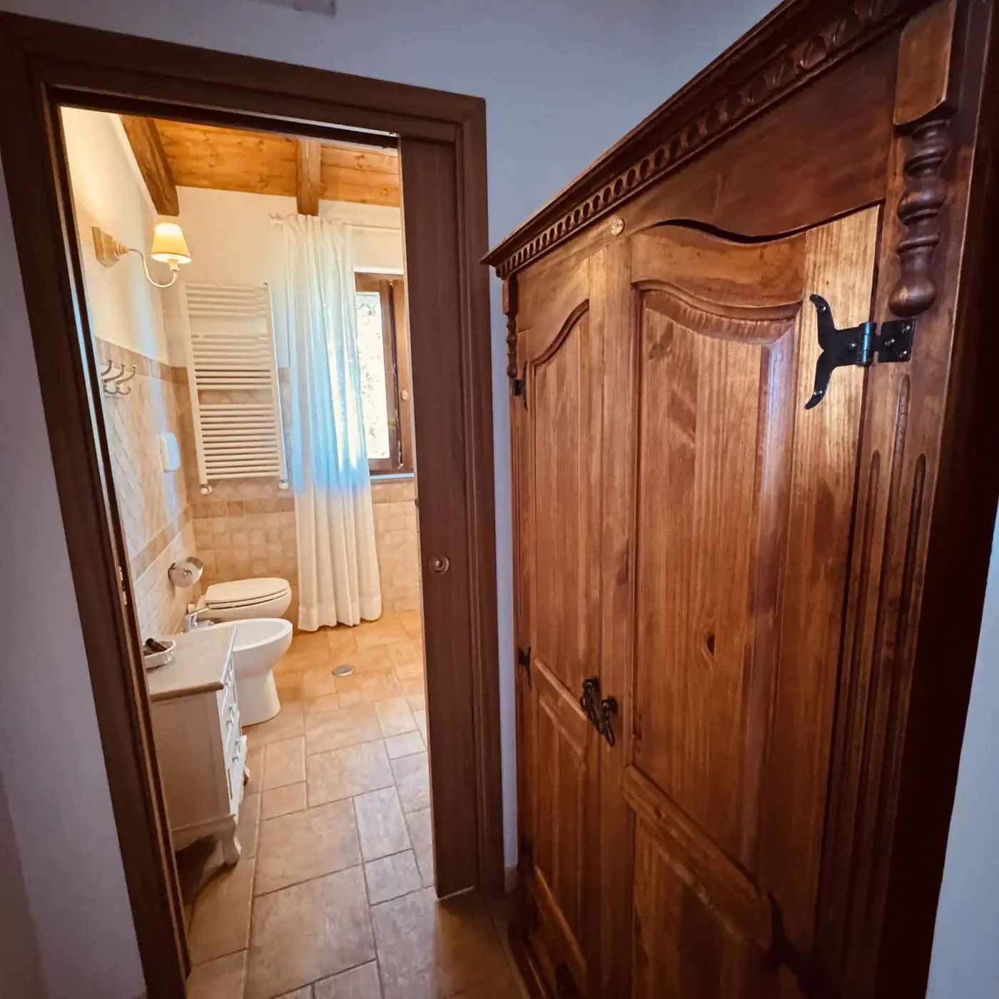 Dettaglio dell'armadio in legno massello e dell'ingresso al bagno di una camera